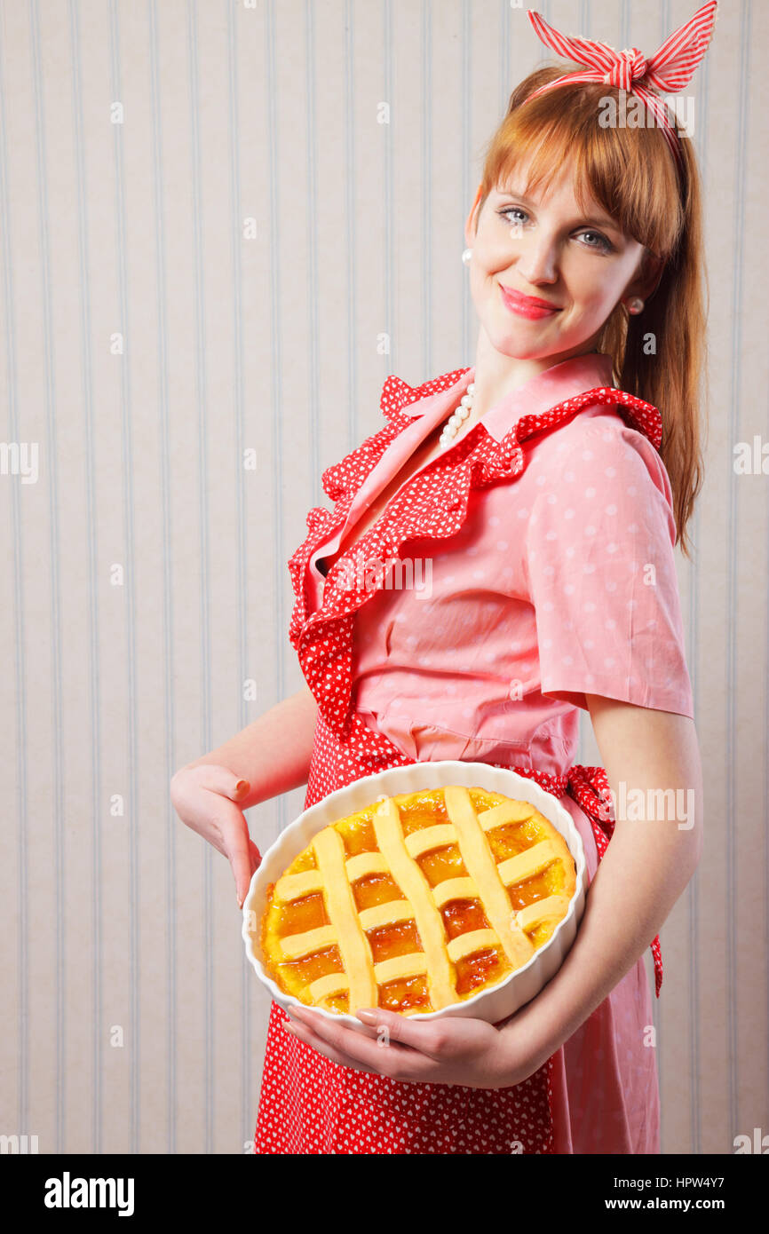 Retro housewife holding hot italian pie. Stock Photo