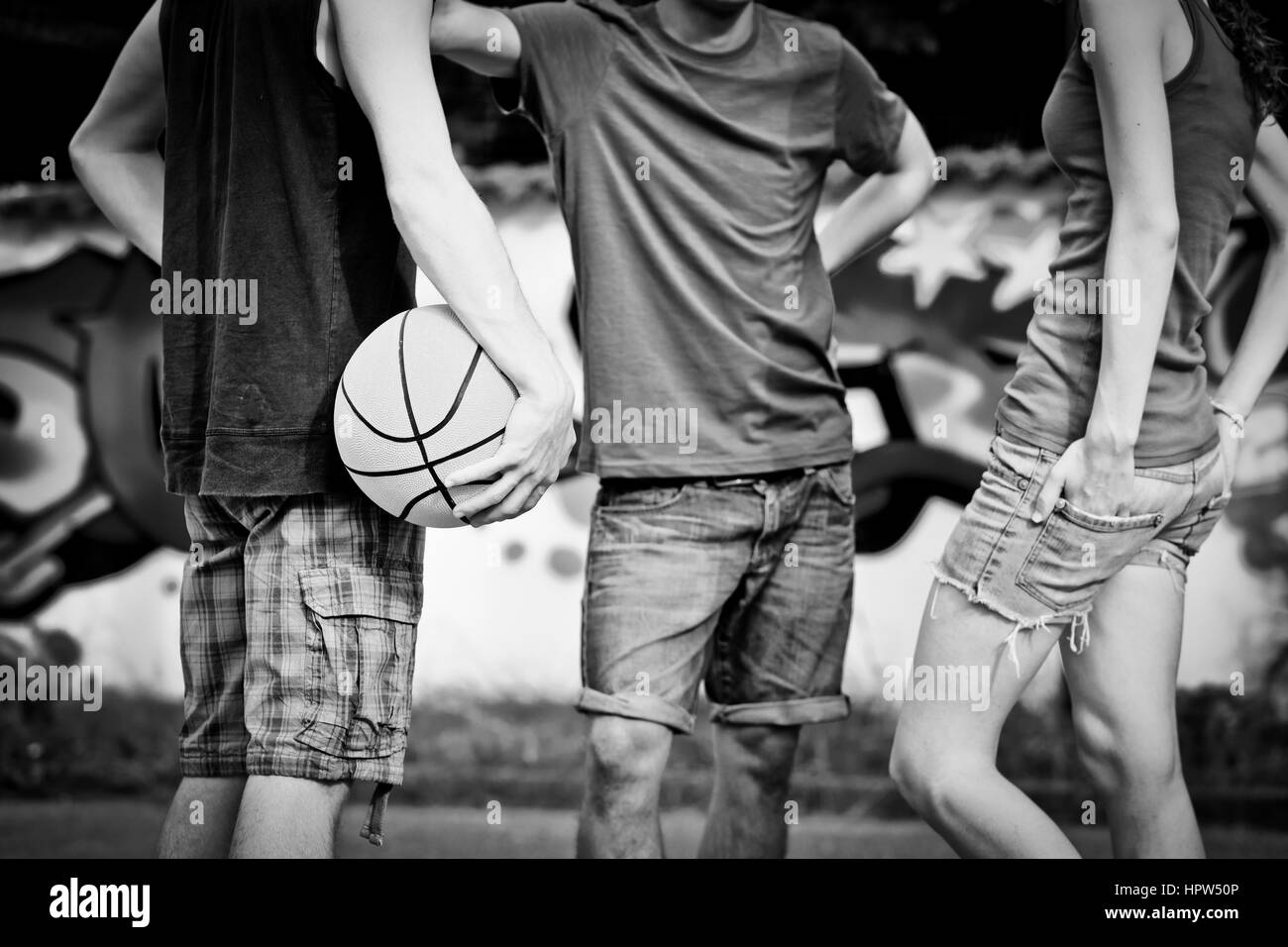 Group of friends talking and taking a break after playing basketball Stock Photo
