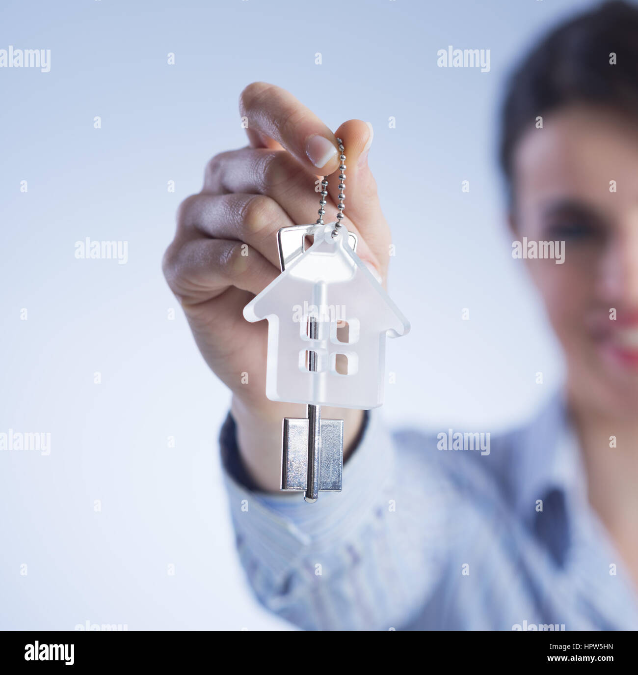 Real estate agent holding out house keys and smiling Stock Photo - Alamy