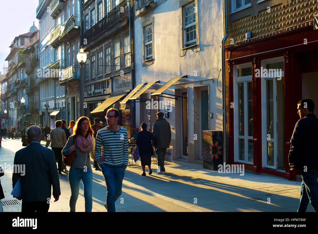 PORTO, PORTUGAL - NOV 18, 2016: People walking at Old Town street of Porto at sunset. Porto is the famous tourist destiantion in Portugal Stock Photo