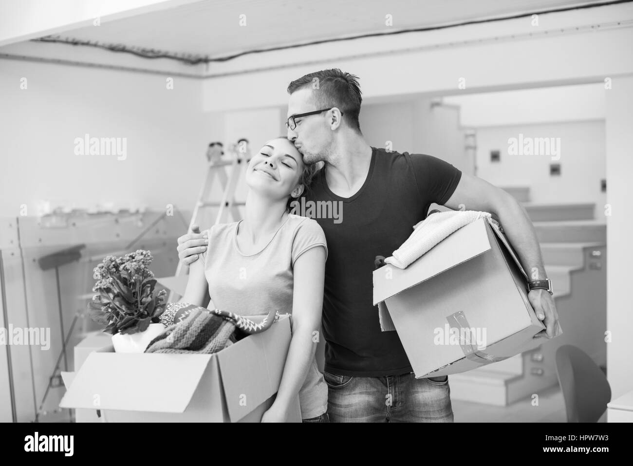 Happy young couple unpacking or packing boxes and moving into a new home Stock Photo