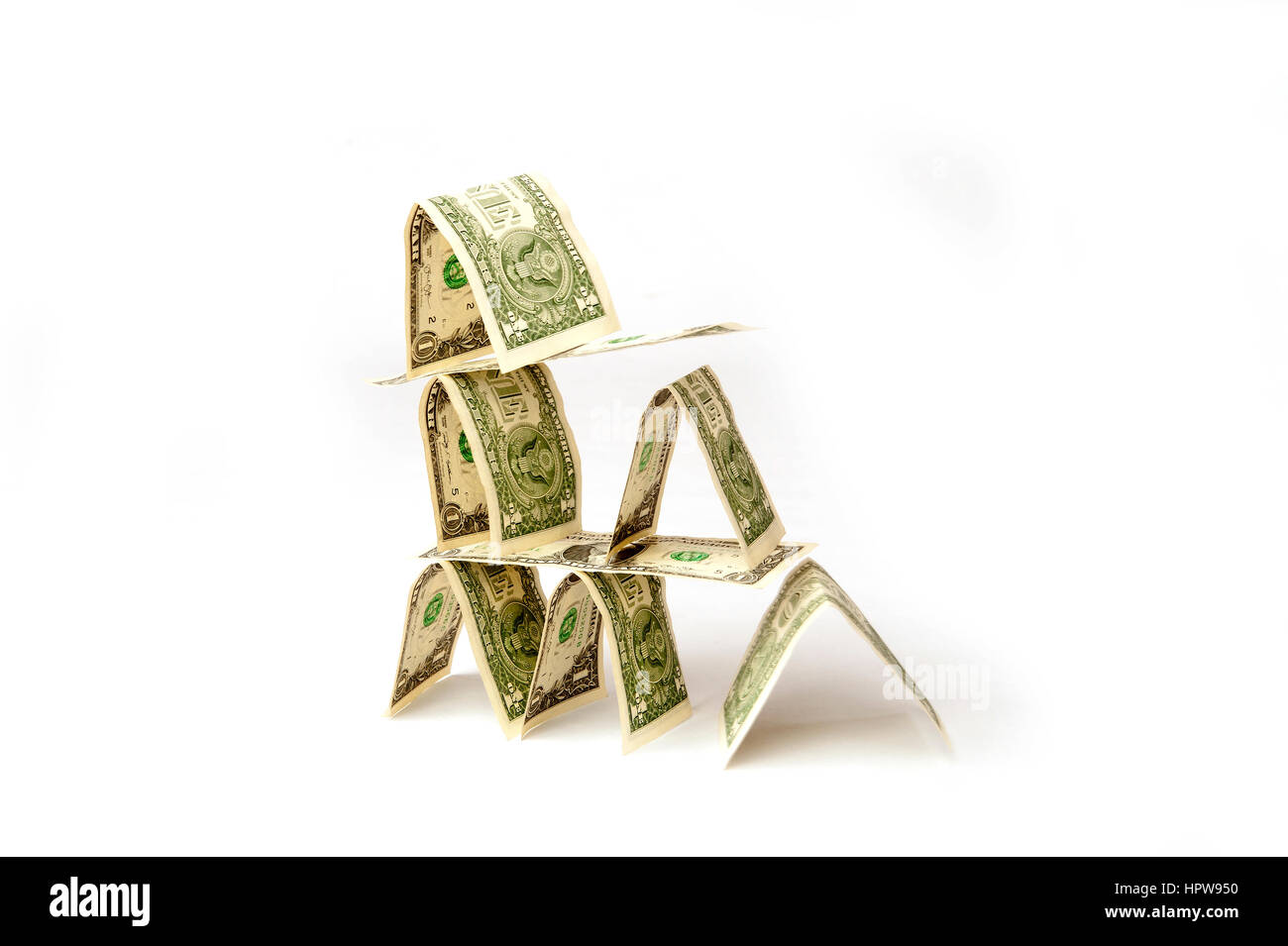 House built with U.S. dollar bills collapsing illustrating uncertainty in financial future. Stock Photo