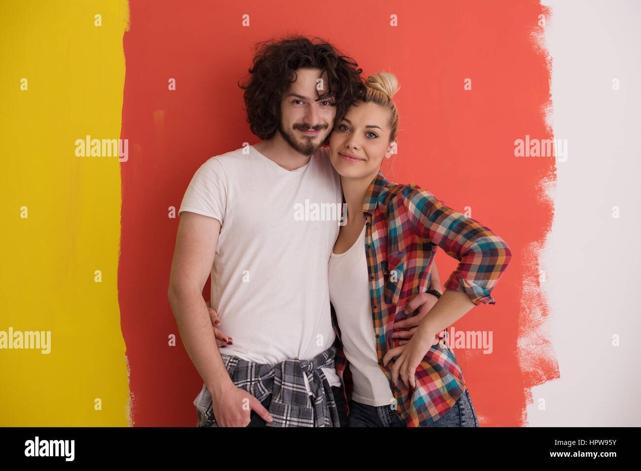 Portrait of a happy young smiling couple in love over color background ...