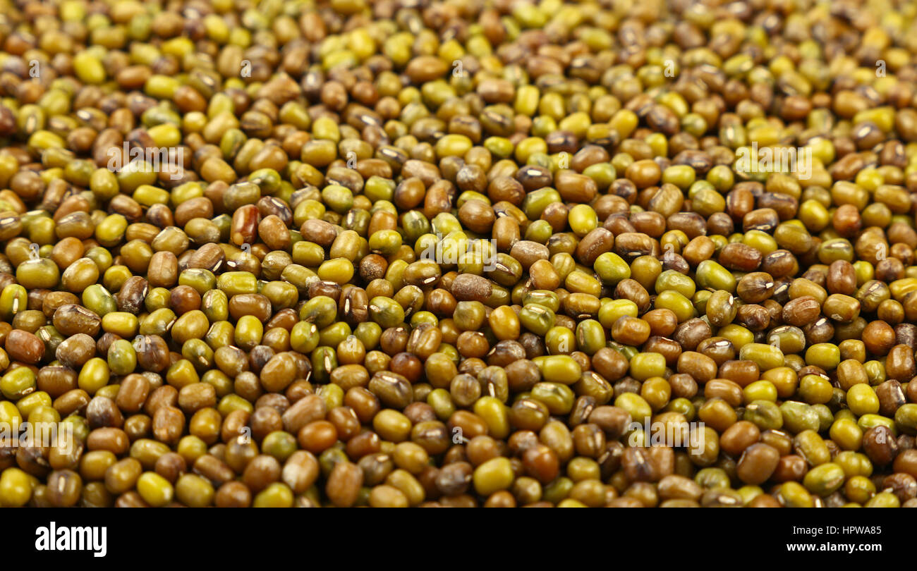 Green and brown dried Asian traditional mung (moong) gram beans atretail market display, close up pattern background, low angle view Stock Photo