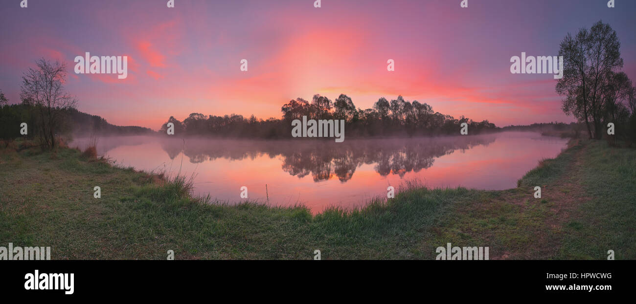 Colorful sunrise above misty lake pink colours reflection Stock Photo