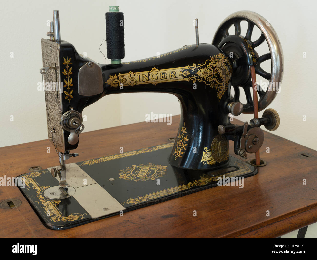Close up view of an old Singer treadle sewing machine with thread on the  bobbin, held together with rope but still working Stock Photo - Alamy