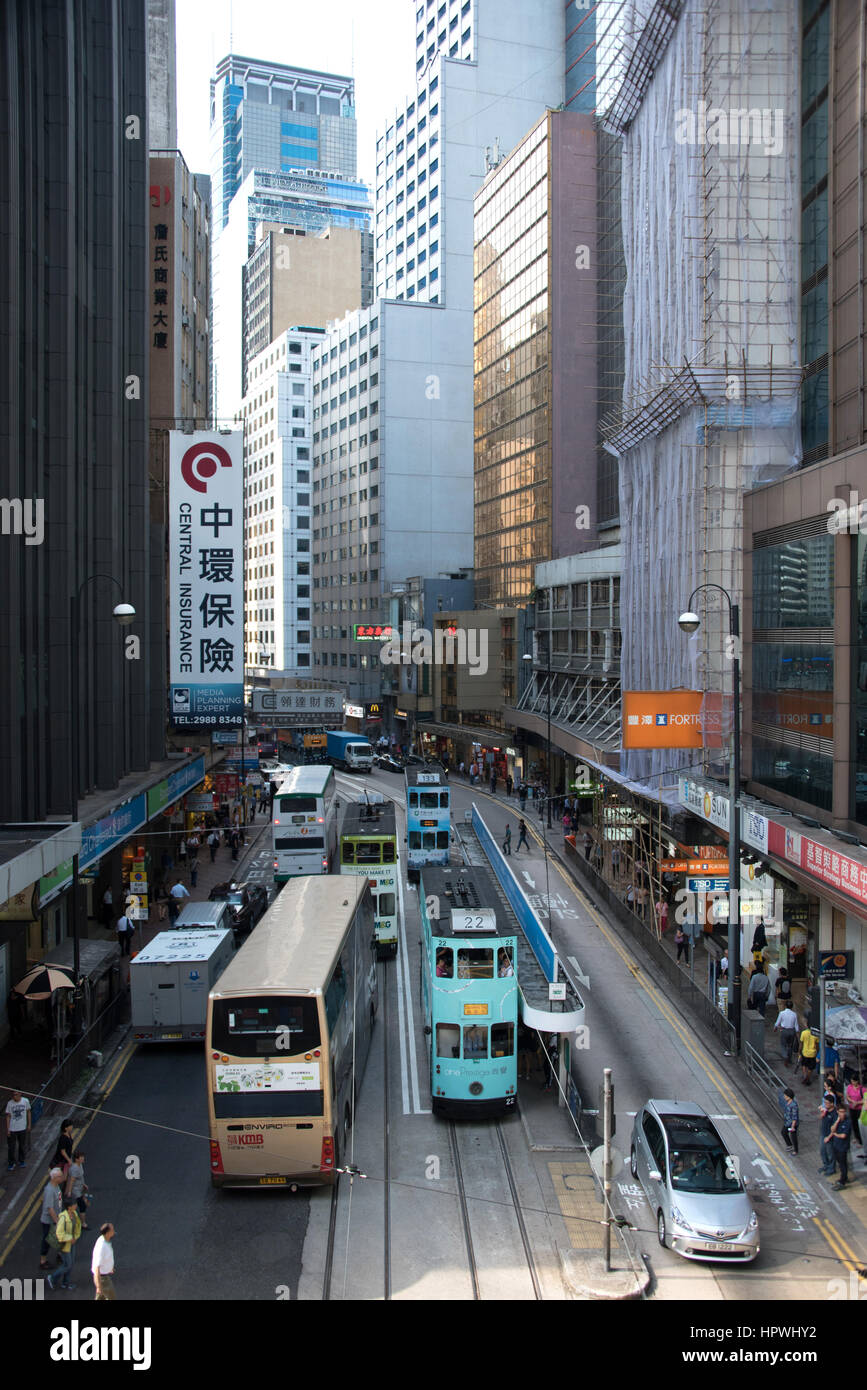 City Scene in Hong Kong with buildings, buses, trams and pedestrians Stock Photo