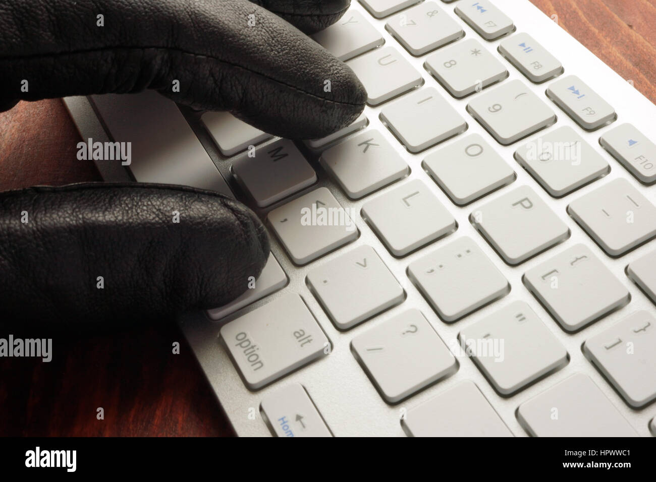 Hand in black glove types on keyboard. Stock Photo