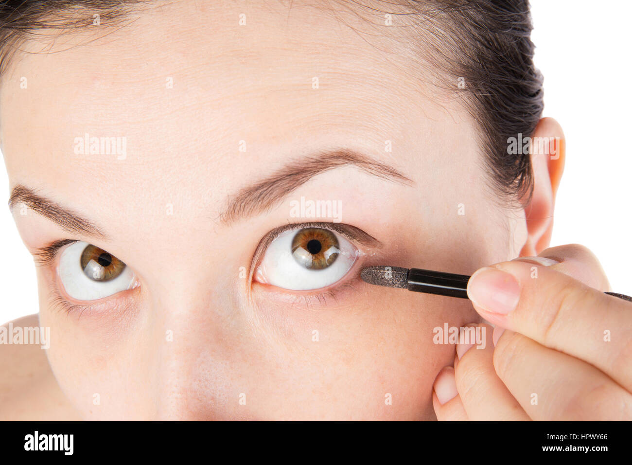 Young girl is doing her makeup with brush isolated on white Stock Photo