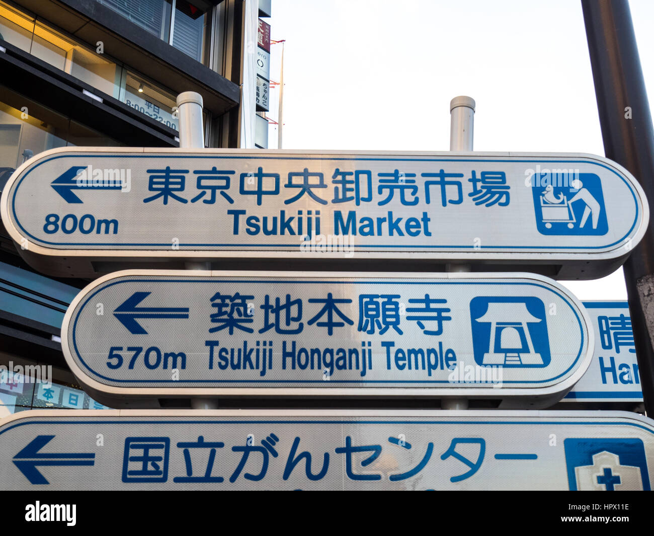 Two street signs, one for the Tsukiji Markets commonly known as the Tokyo Fish Markets, and Tsukiji Honganji Temple. Stock Photo