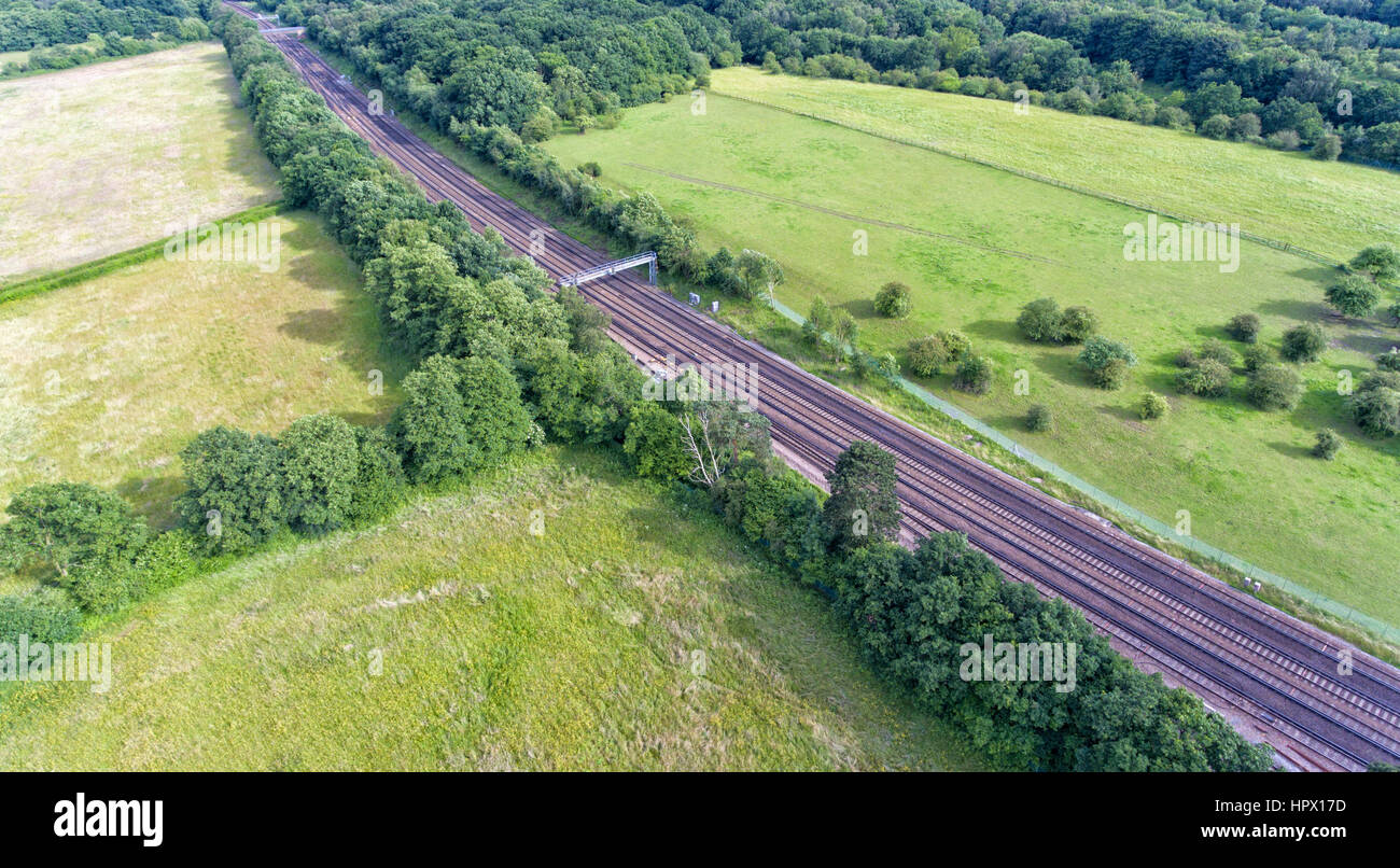 Aerial view of train rail tracks through English, green countryside, on