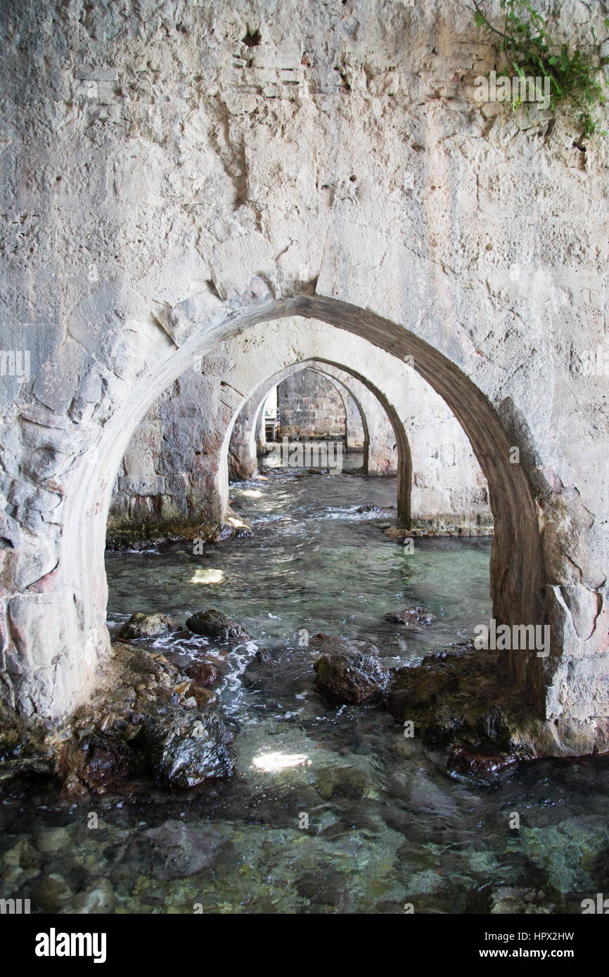 Arches made of stone inside shipyard of Alanay medieval castle built in XIII century by Alaeddin Keykubat with turquoise water Stock Photo