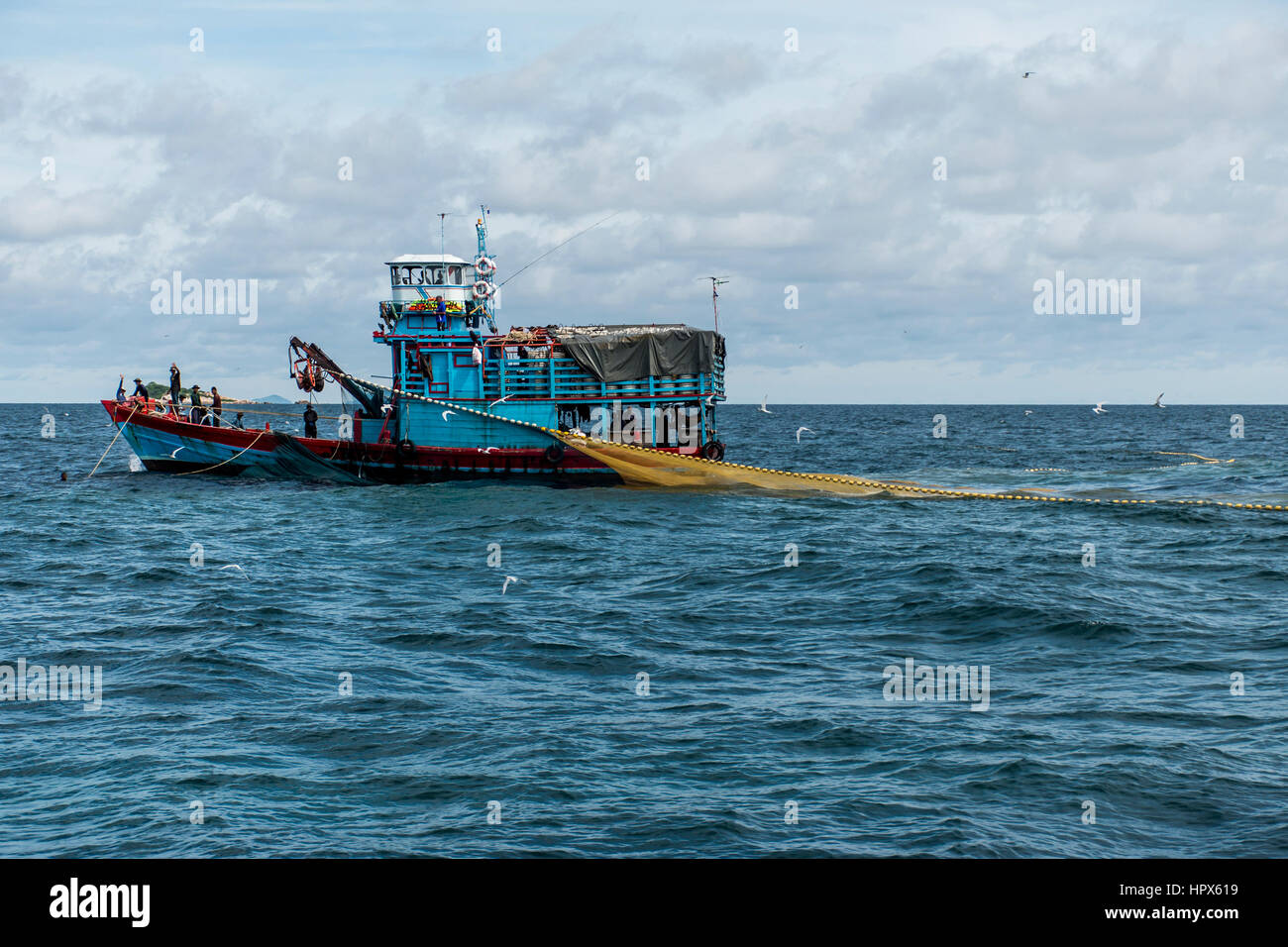 Fishing boat big fishermen with fish huge net on the blue ocean
