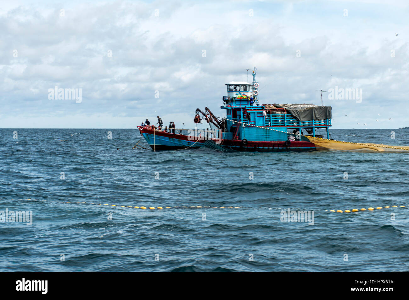 Fishermen catch fish with a huge fishing net with a length of