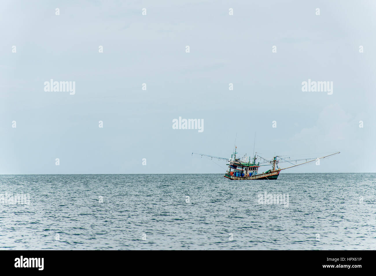 Fishing boat big fishermen with fish huge net on the blue ocean