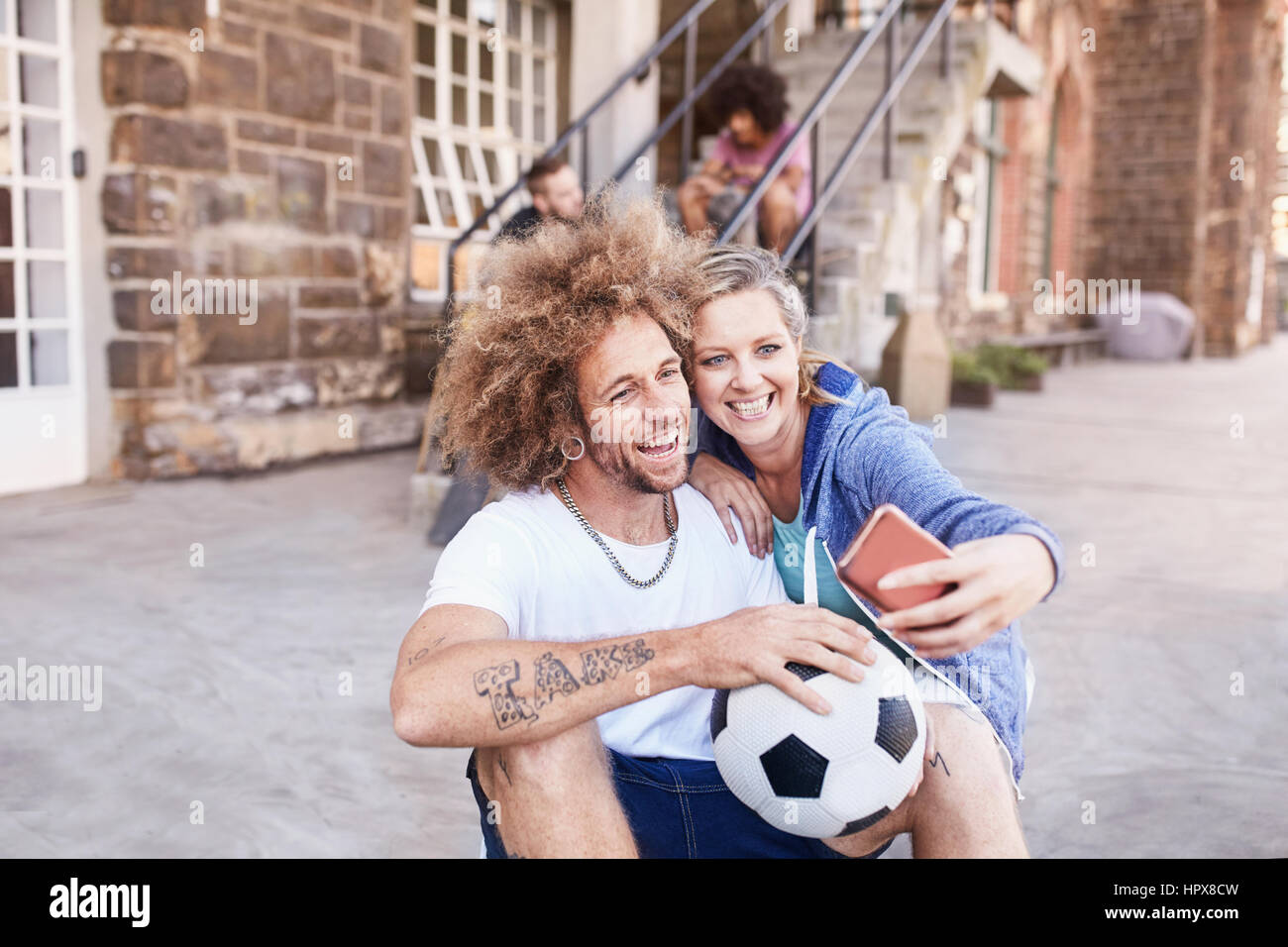 Couple with soccer ball taking selfie with camera phone Stock Photo