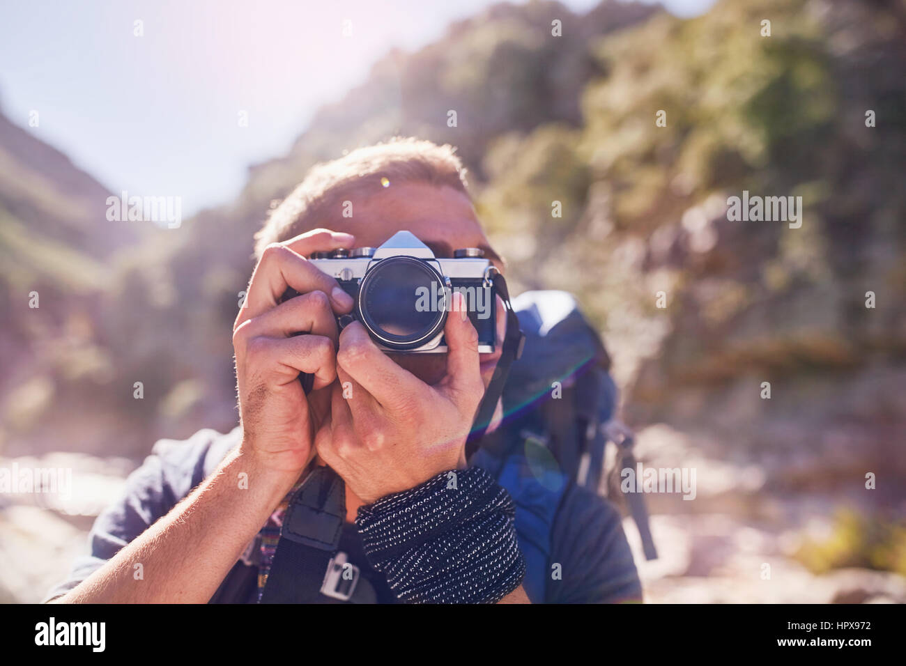 Young man hiking, photographing with camera Stock Photo