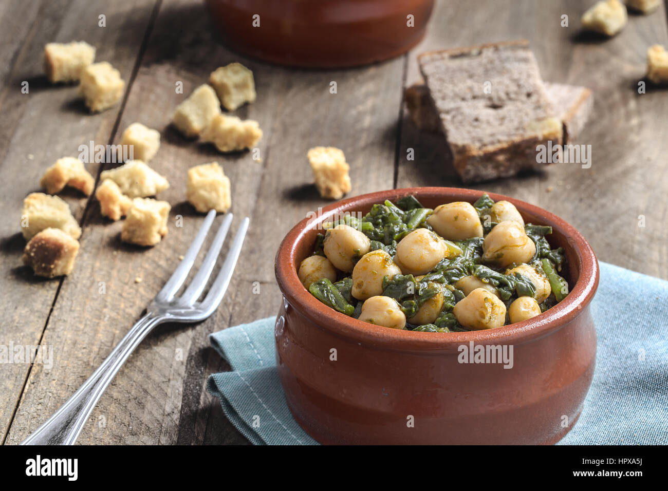 Chickpea and spinach stew on rustic wooden background. Spanish cuisine