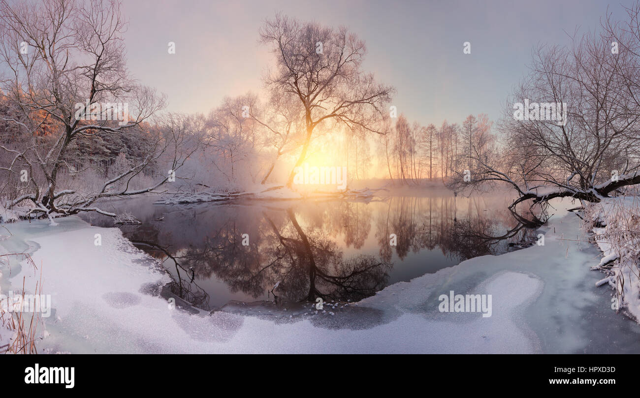 Sunny winter morning. First ice on lake. Frosty winter landscape. Colorful christmas background. Stock Photo