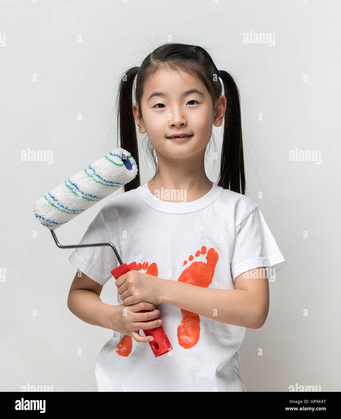 Cute asian girl holding paint roller Stock Photo Alamy