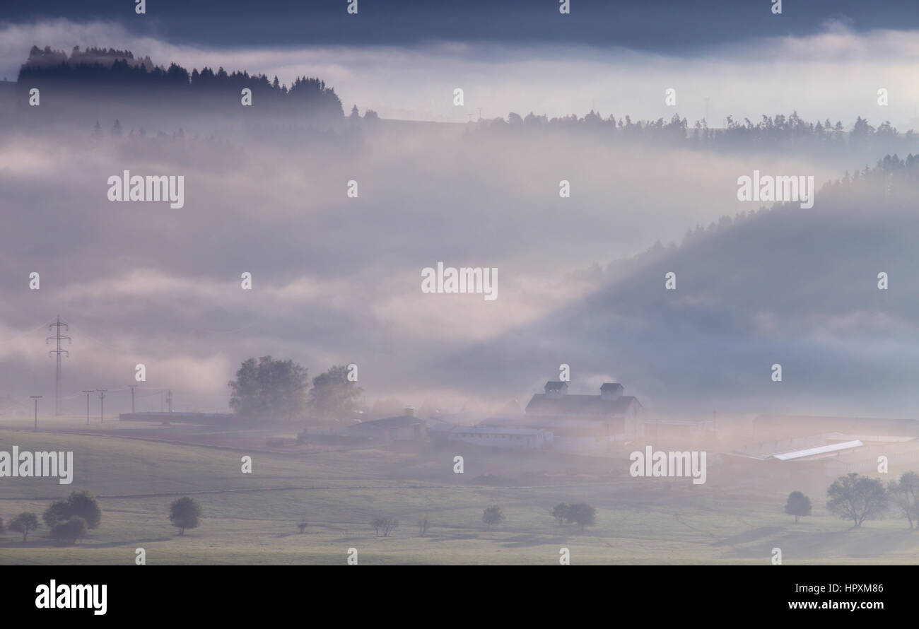 Misty morning in mountains with small house and forest Stock Photo - Alamy