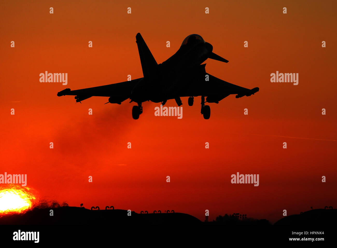 RAF Typhoon silhouetted against the setting sun powering back into the visual circuit at Coningsby. Stock Photo