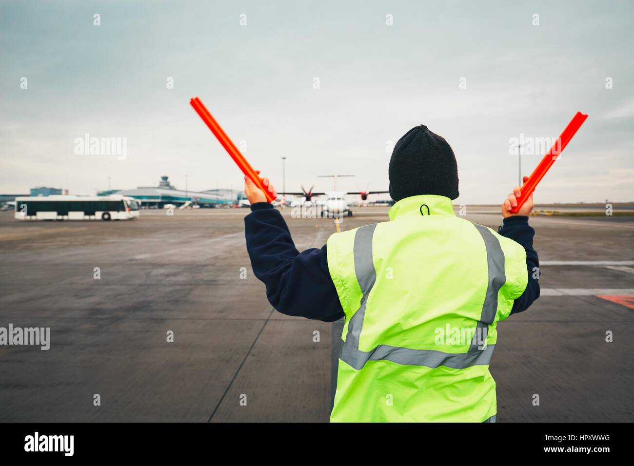 PRAGUE, CZECH REPUBLIC - DECEMBER 1, 2016: Aircraft marshaller during visual signalling for pilots after landing. Vaclav Havel Airport Prague on Decem Stock Photo