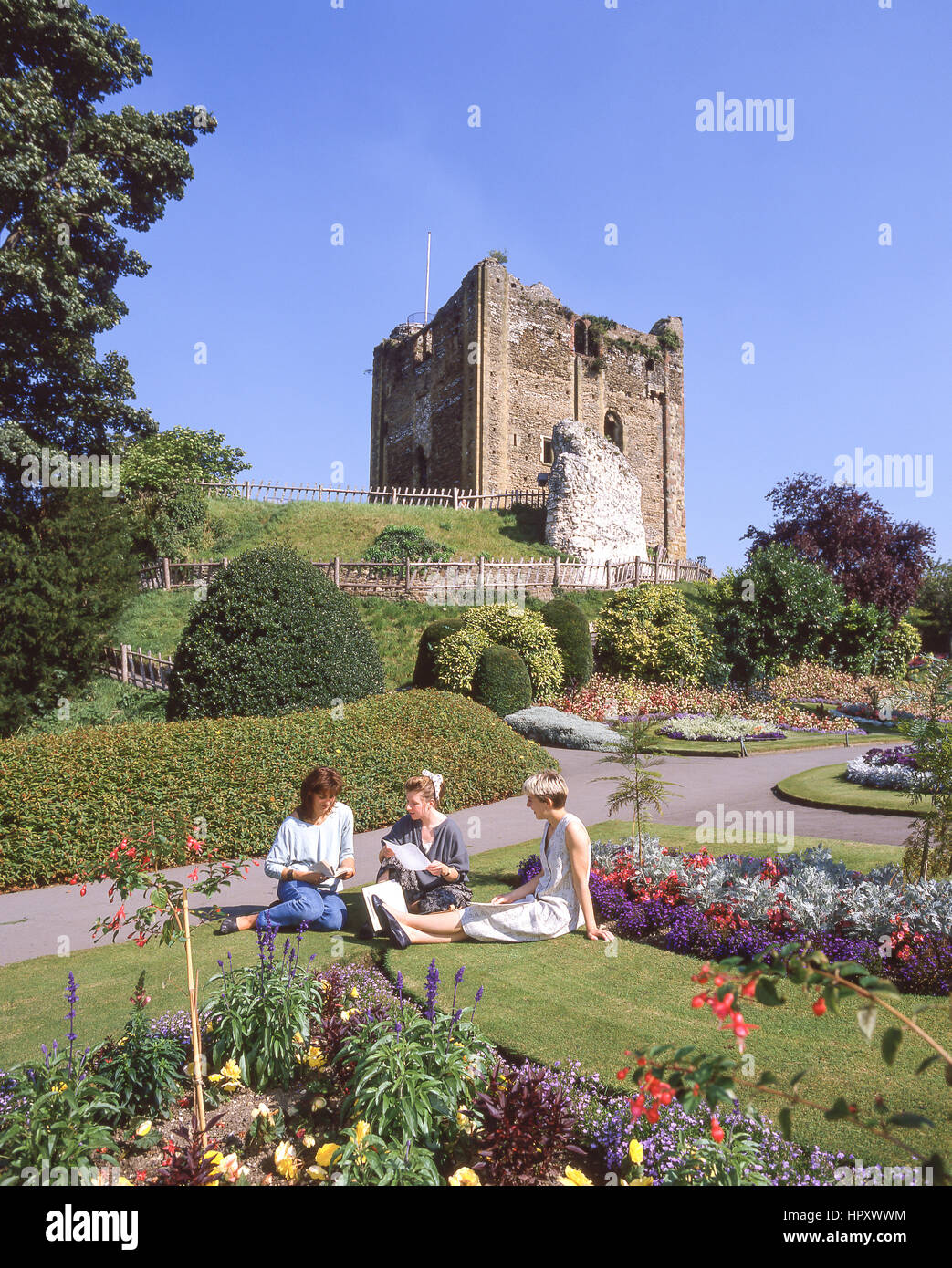 Young female students sitting in grounds of Guildford Castle, Guildford, Surrey, England, United Kingdom Stock Photo