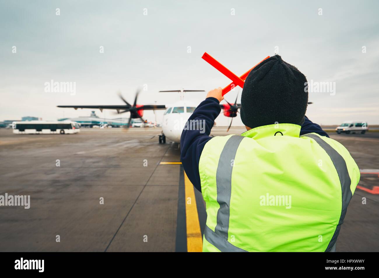 PRAGUE, CZECH REPUBLIC - DECEMBER 1, 2016: Aircraft marshaller during visual signalling for pilots after landing. Vaclav Havel Airport Prague on Decem Stock Photo