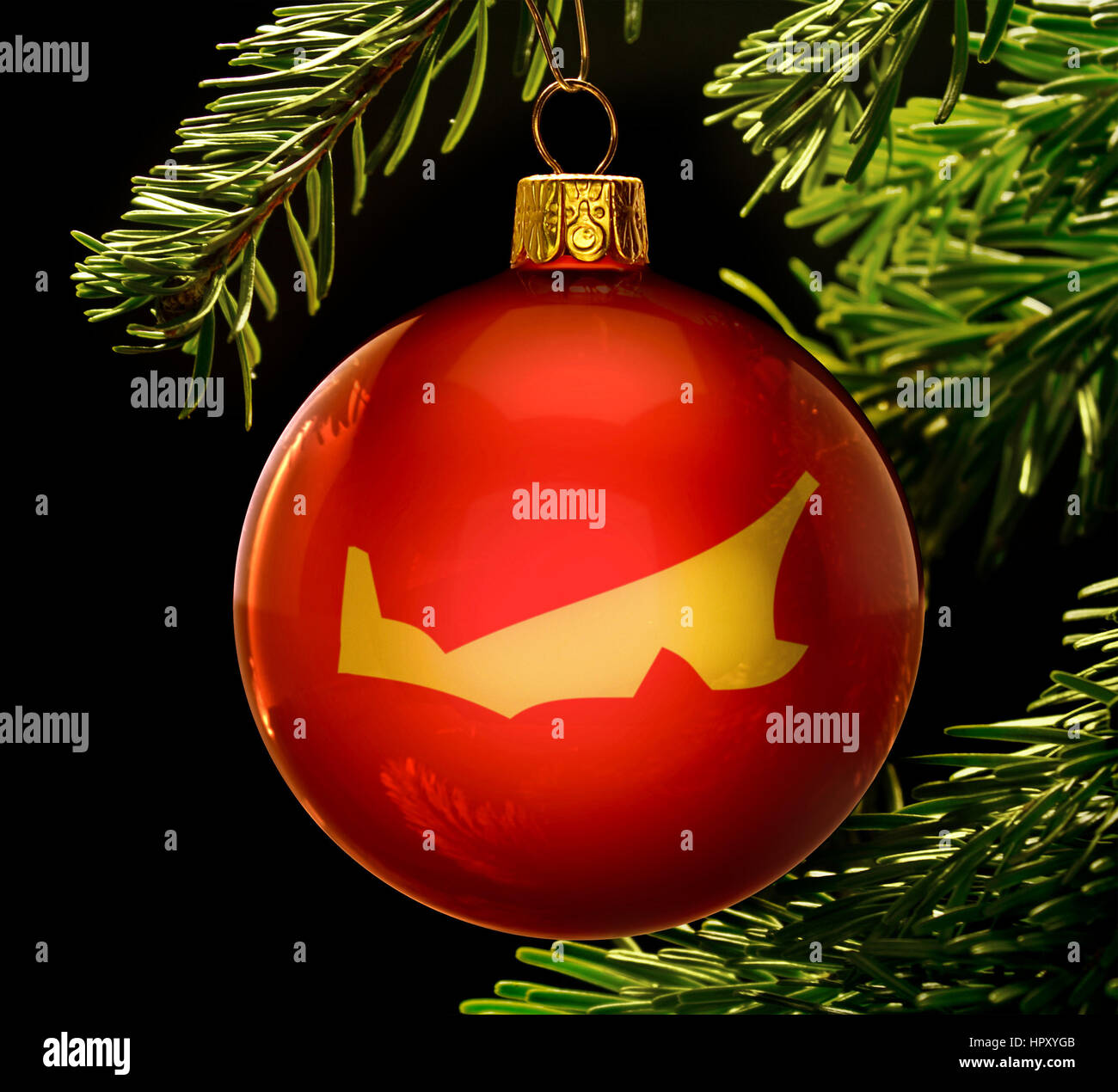 A red bauble with the golden shape of  Prince Edward Island hanging on a christmas tree isolated on black.(series) Stock Photo