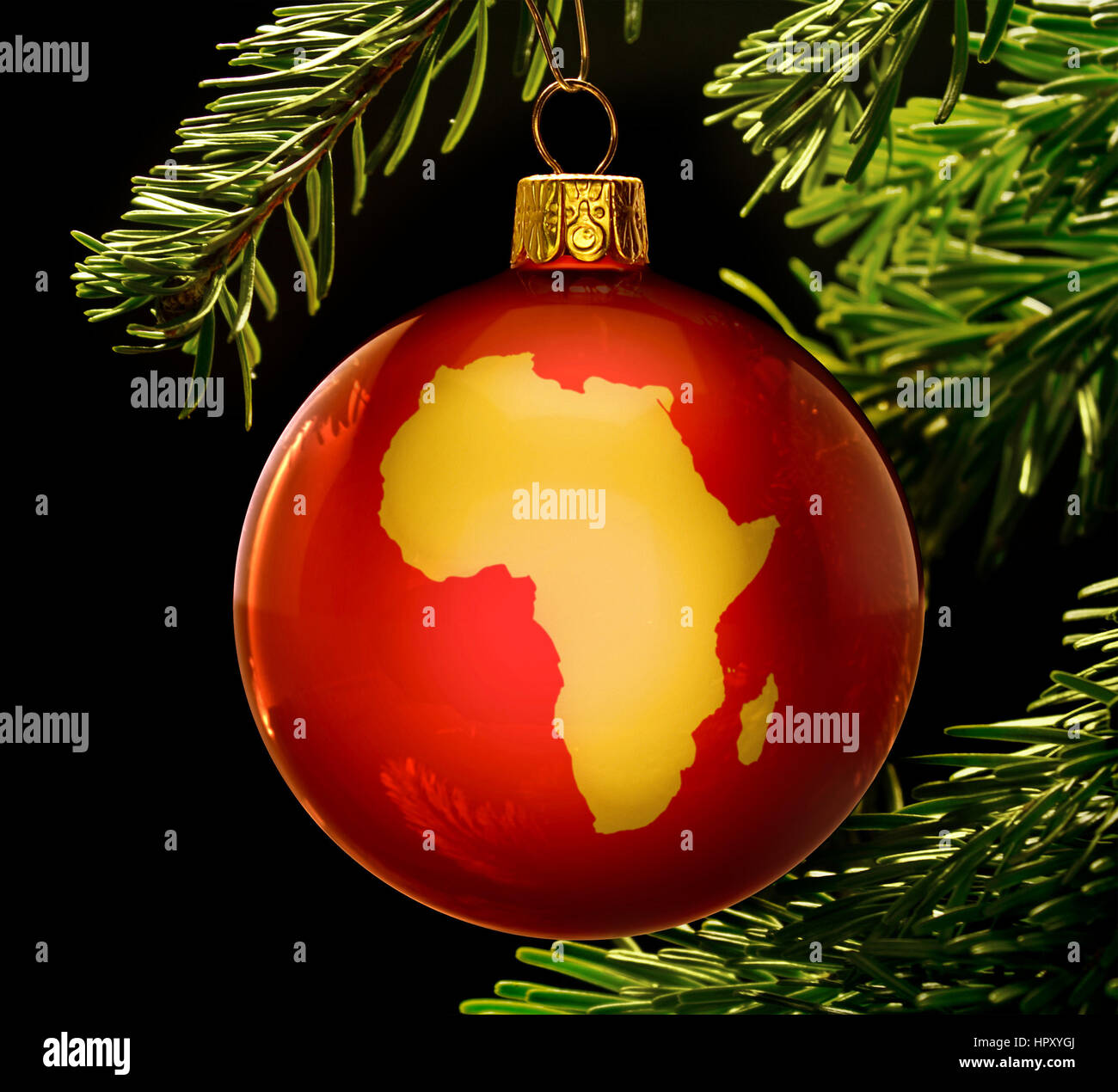 A red bauble with the golden shape of Africa hanging on a christmas tree isolated on black