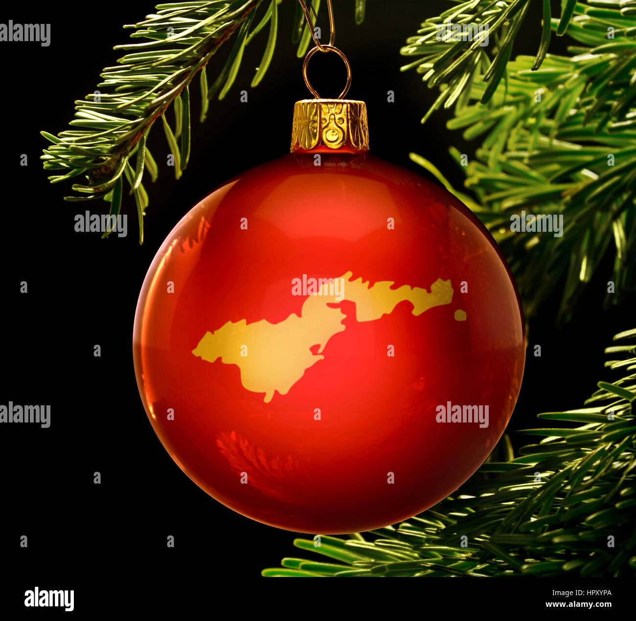 A red bauble with the golden shape of  American Samoa hanging on a christmas tree isolated on black.(series) Stock Photo