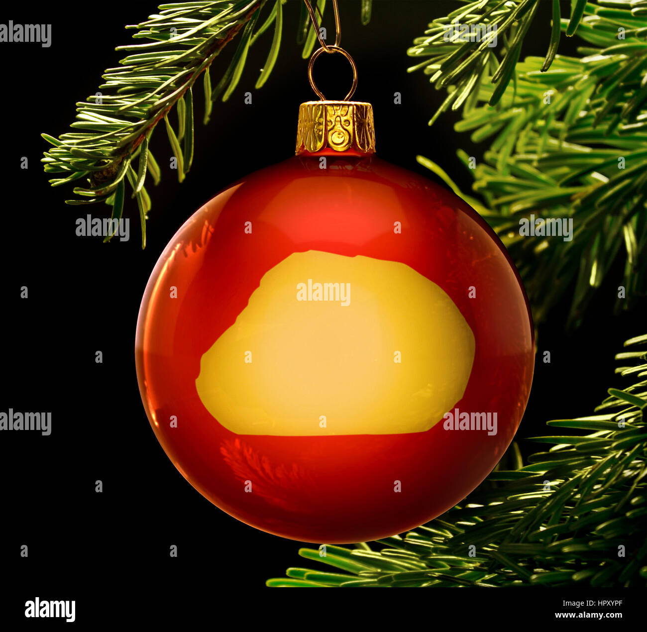 A red bauble with the golden shape of  Baker Island hanging on a christmas tree isolated on black.(series) Stock Photo