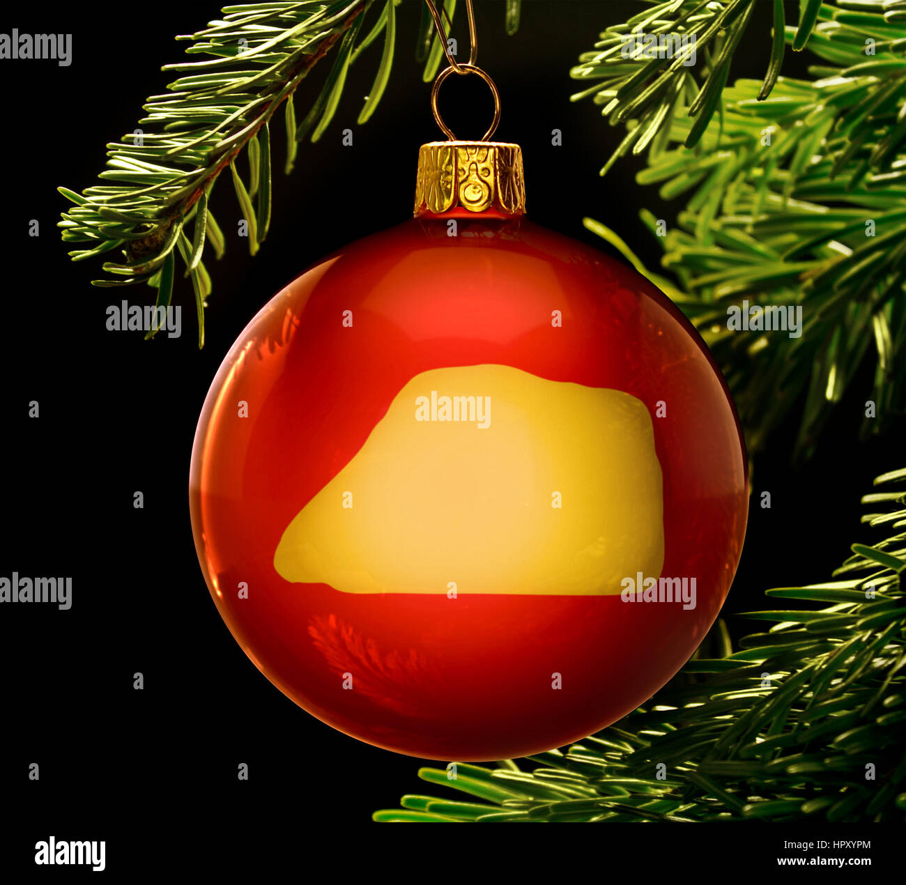 A red bauble with the golden shape of  Jarvis Island hanging on a christmas tree isolated on black.(series) Stock Photo