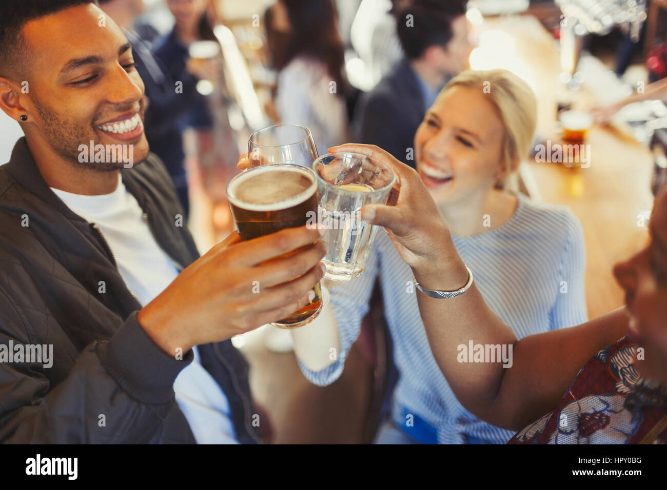 Enthusiastic friends toasting beer and wine glasses at bar Stock Photo