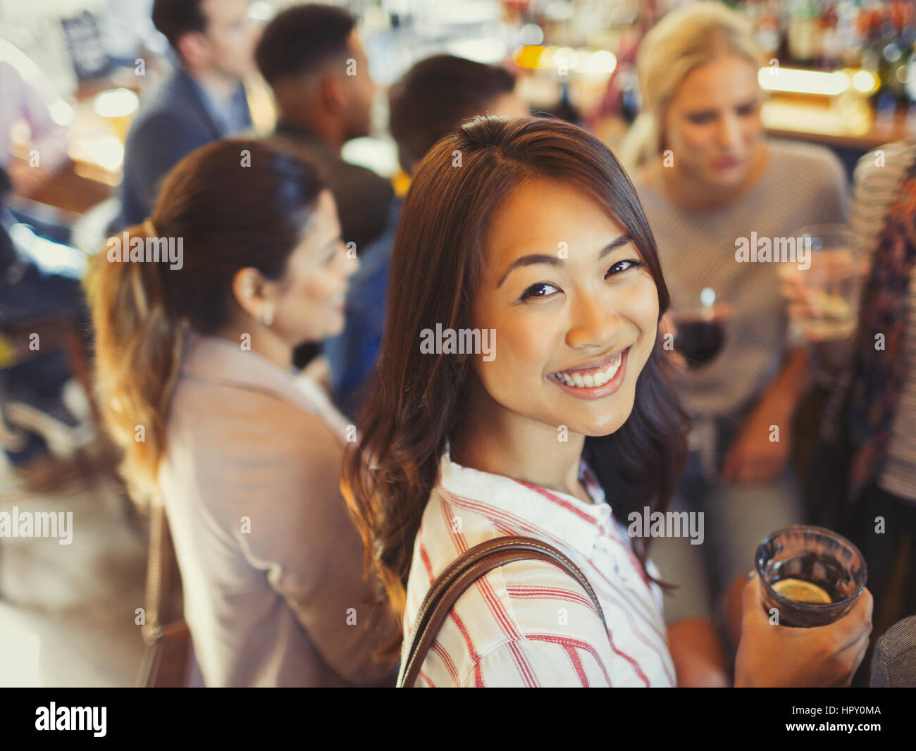 Portrait smiling woman drinking with friends at bar Stock Photo