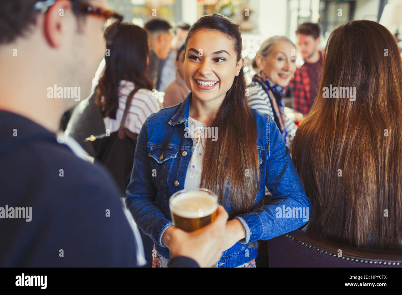 Man and woman drinking beer and talking at bar Stock Photo