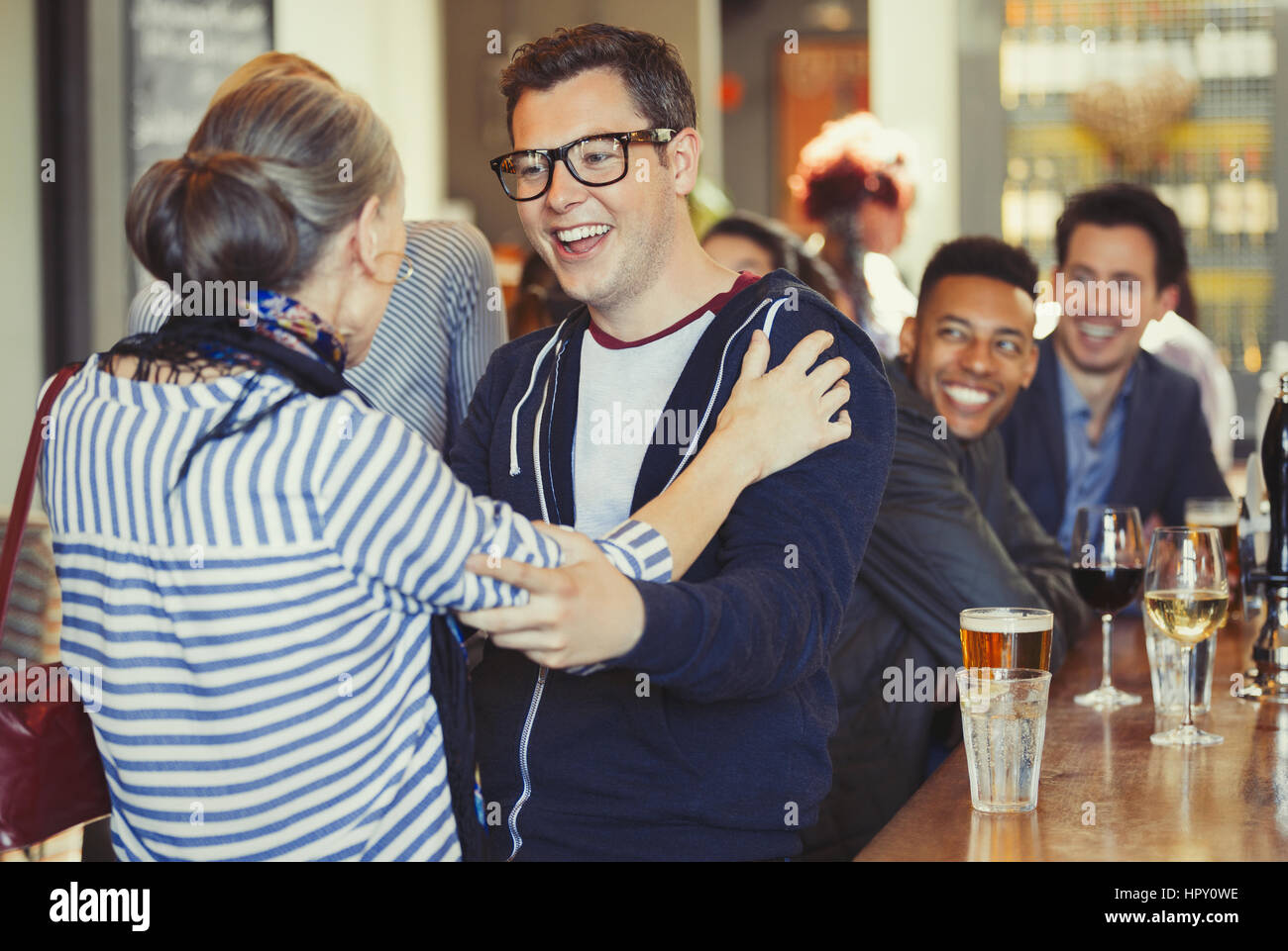 Enthusiastic man and woman greeting at bar Stock Photo