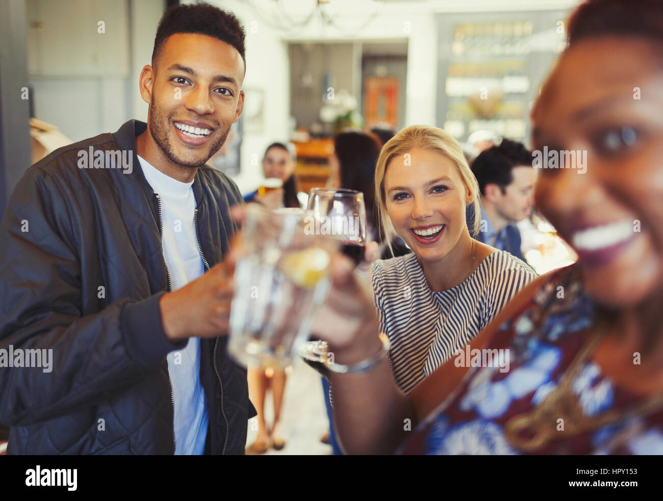 Portrait smiling man drinking with friends in bar Stock Photo