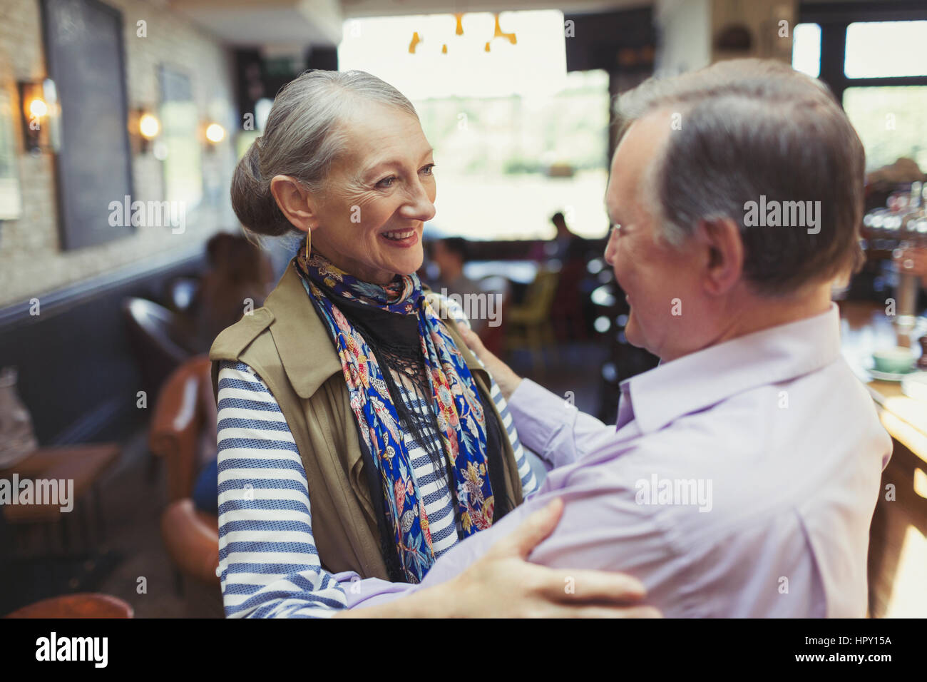 Affectionate senior couple hugging in bar Stock Photo
