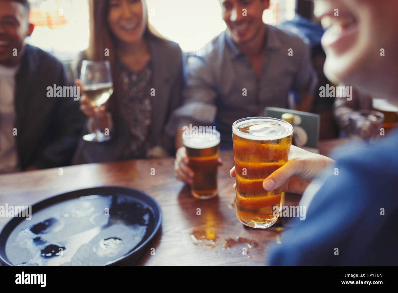Friends drinking beer and wine at table in bar Stock Photo