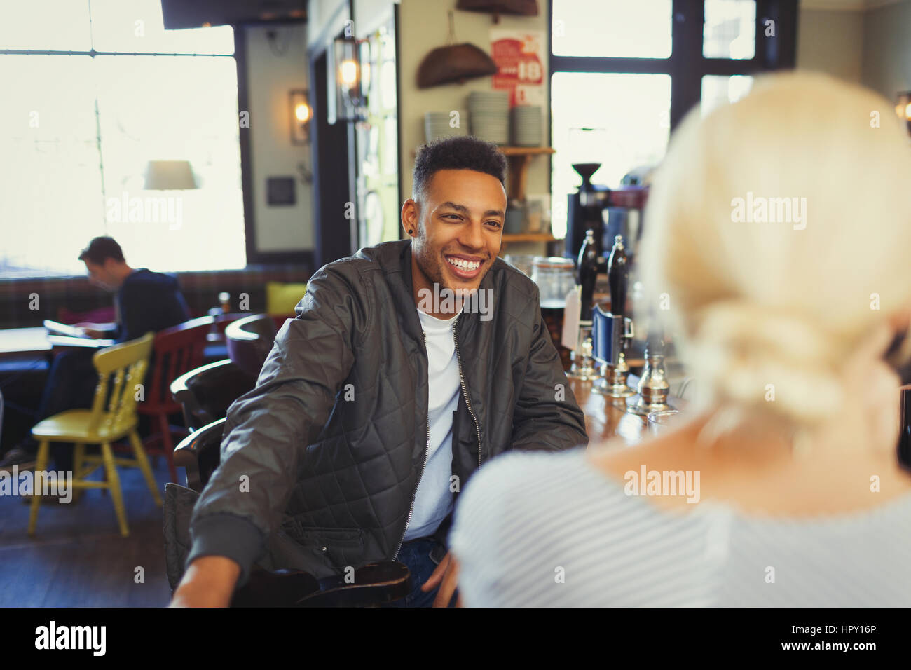 Smiling man talking to woman in bar Stock Photo