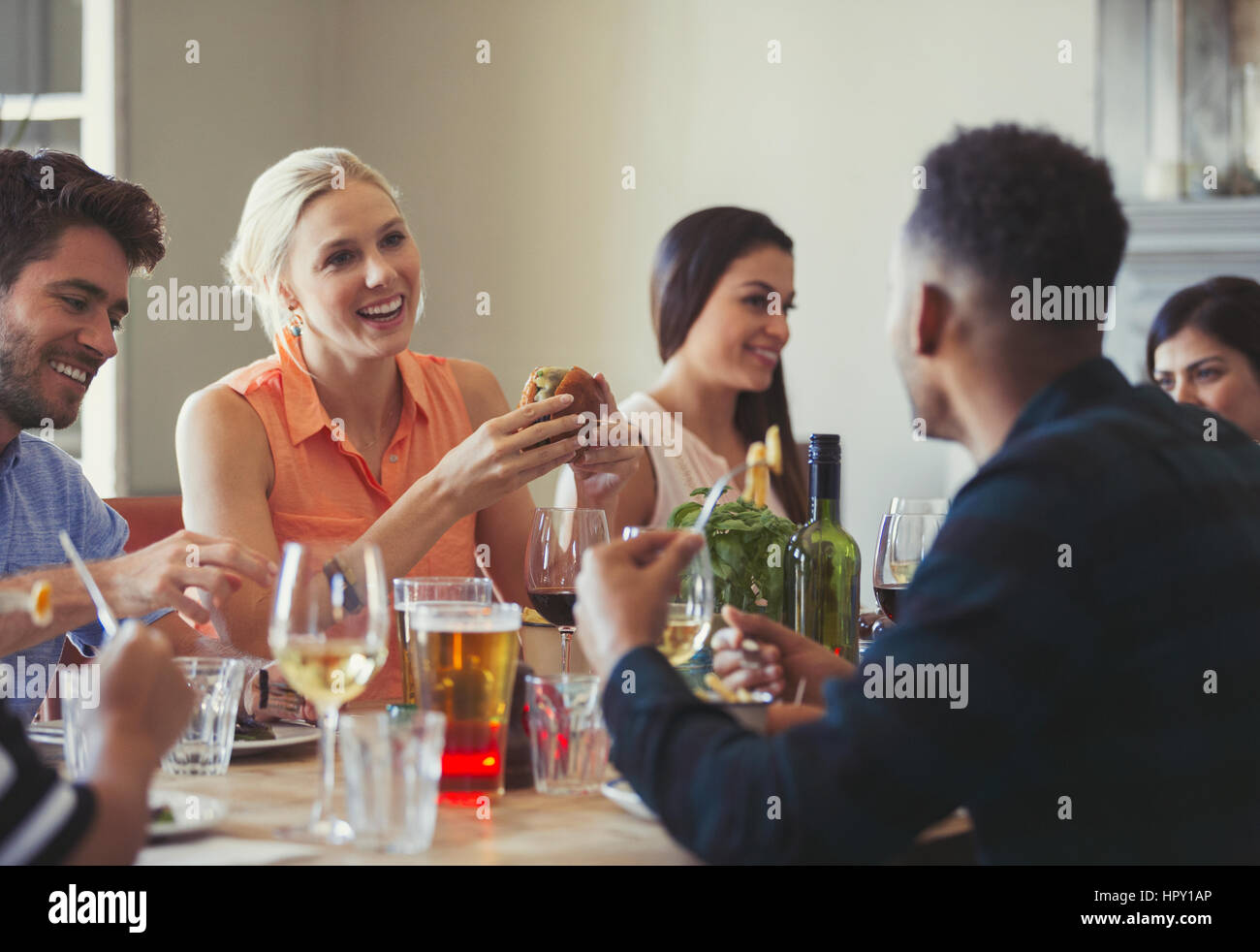 Friends talking and dining at restaurant table Stock Photo