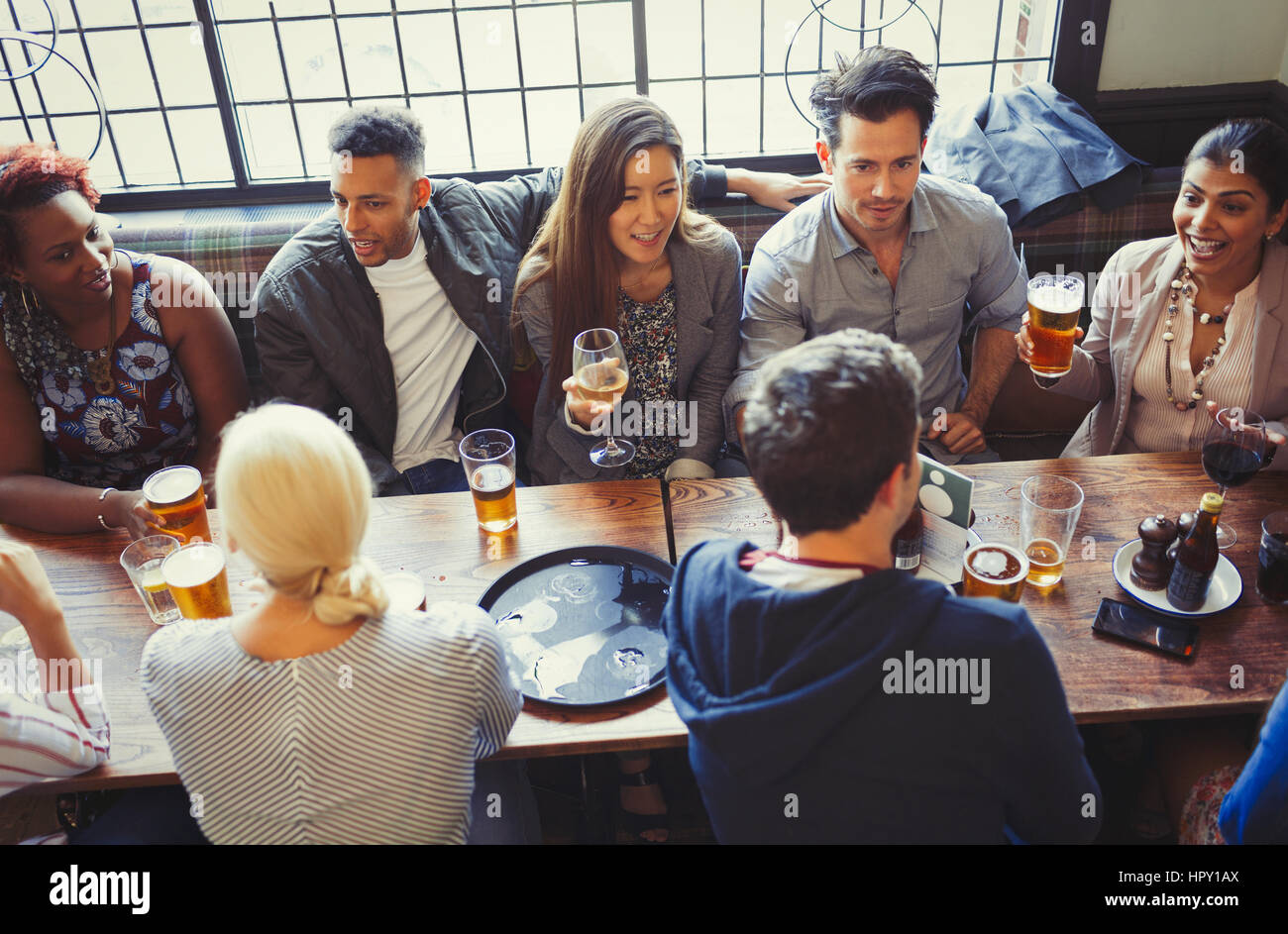 Overhead view of friends drinking beer and wine at table in bar Stock Photo
