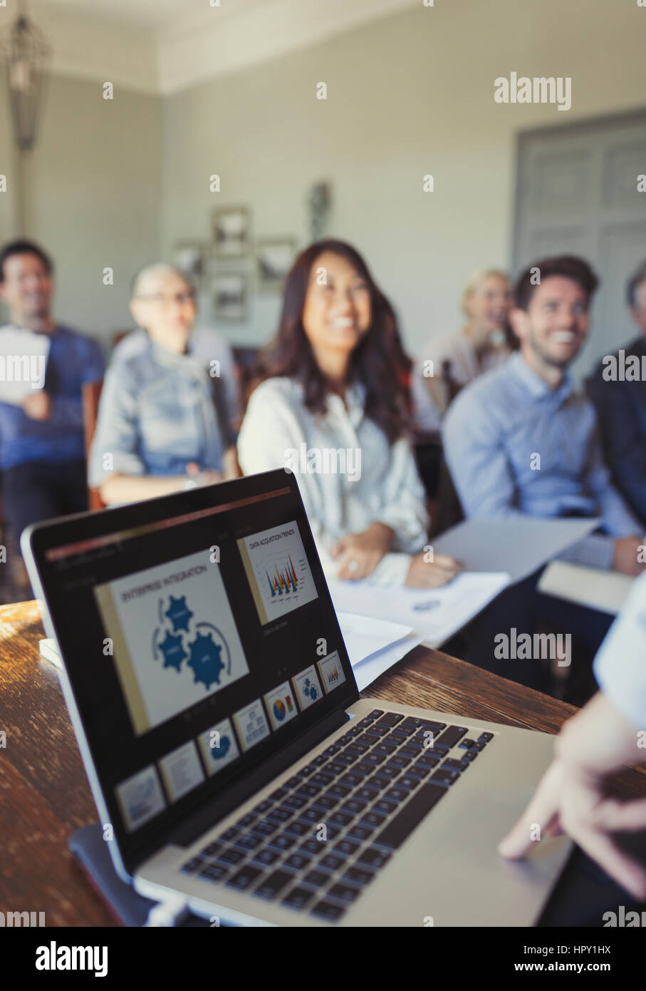 Audience watching businessman at laptop leading conference presentation Stock Photo