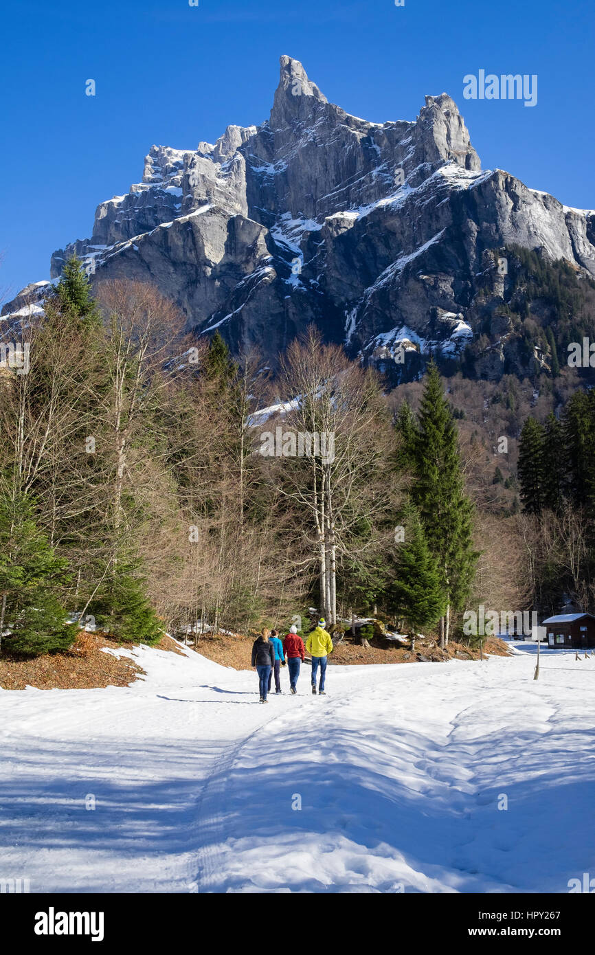 Walkers in Reserve Naturelle de Sixt Fer A Cheval below Pic de Tenneverge in Le massif du Giffre in French Alps in winter. Samoens Haute Savoie France Stock Photo