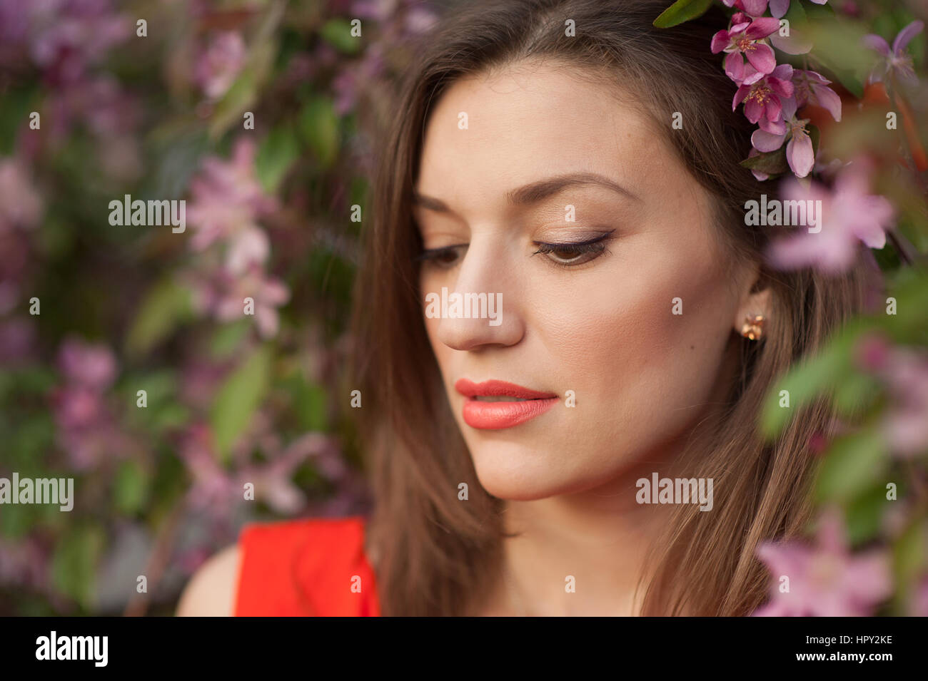 beautiful young woman near the blossoming spring tree. Stock Photo