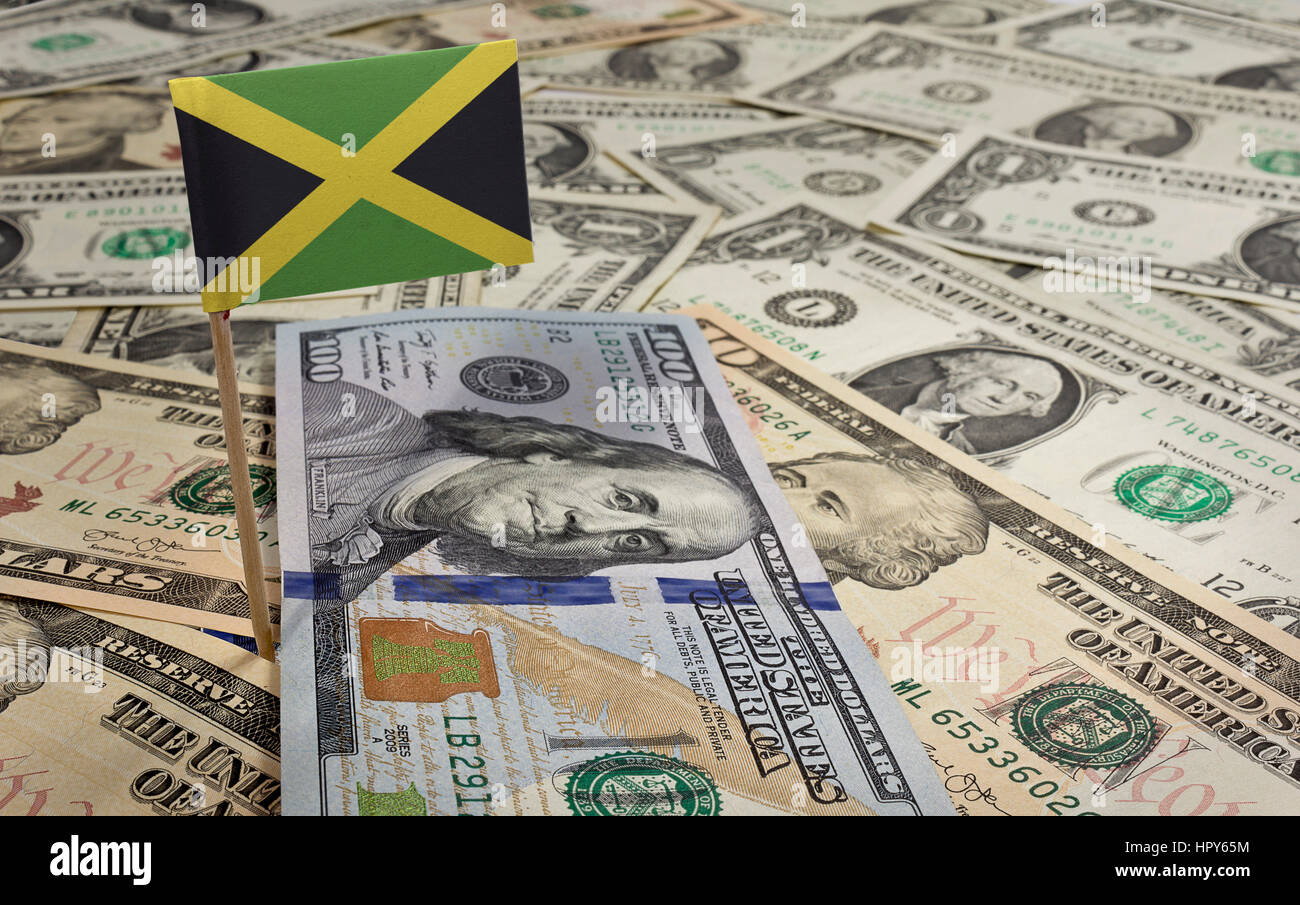 Flag of Jamaica sticking in a variety of american banknotes.(series) Stock Photo