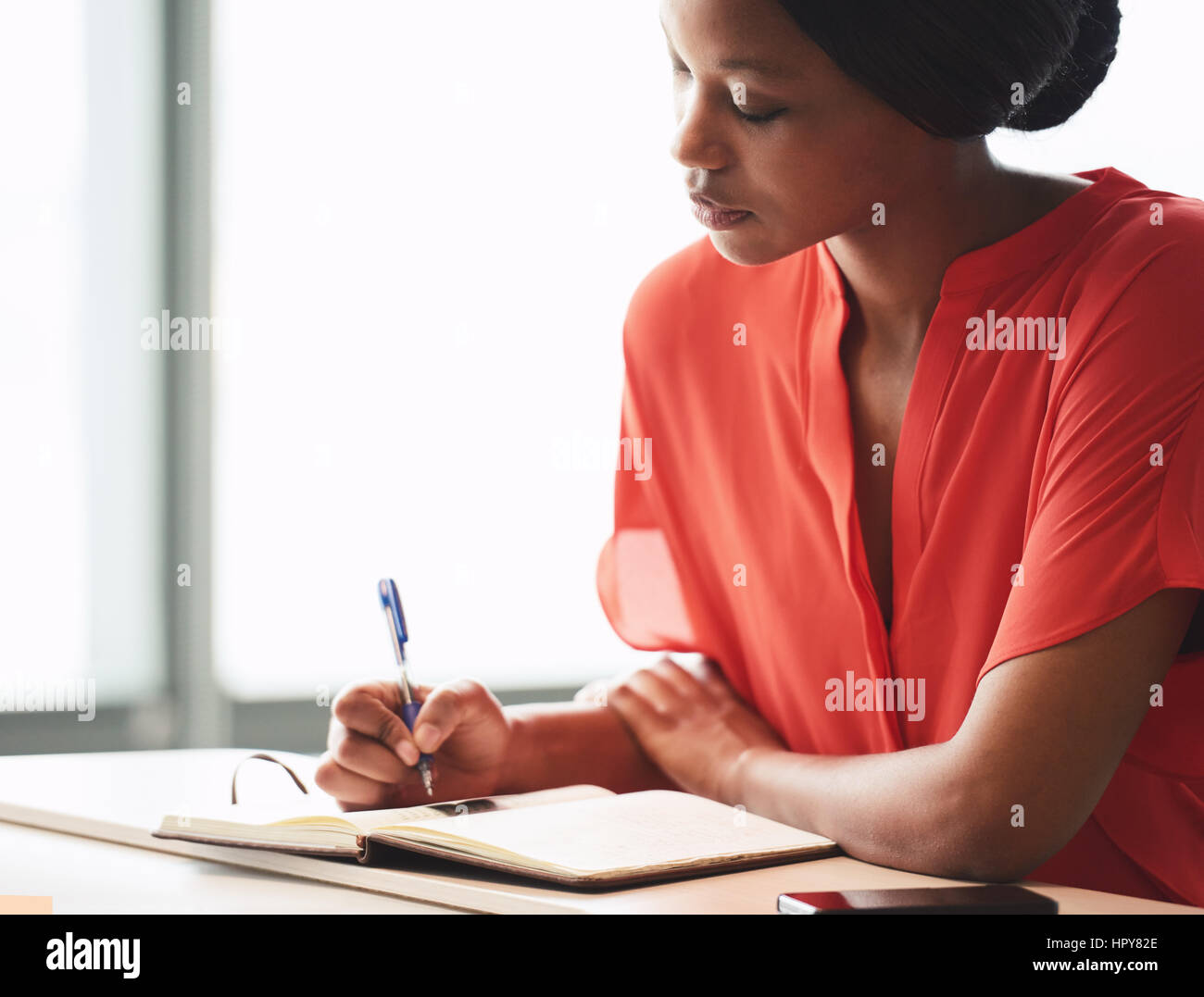 Beautiful young african american writer busy making hand written notes ...