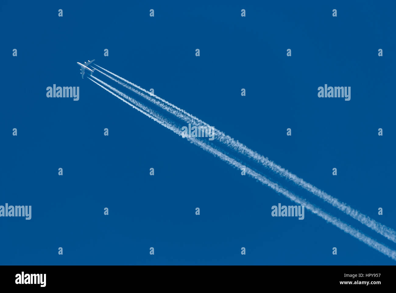 Airplane in blue sky Stock Photo - Alamy